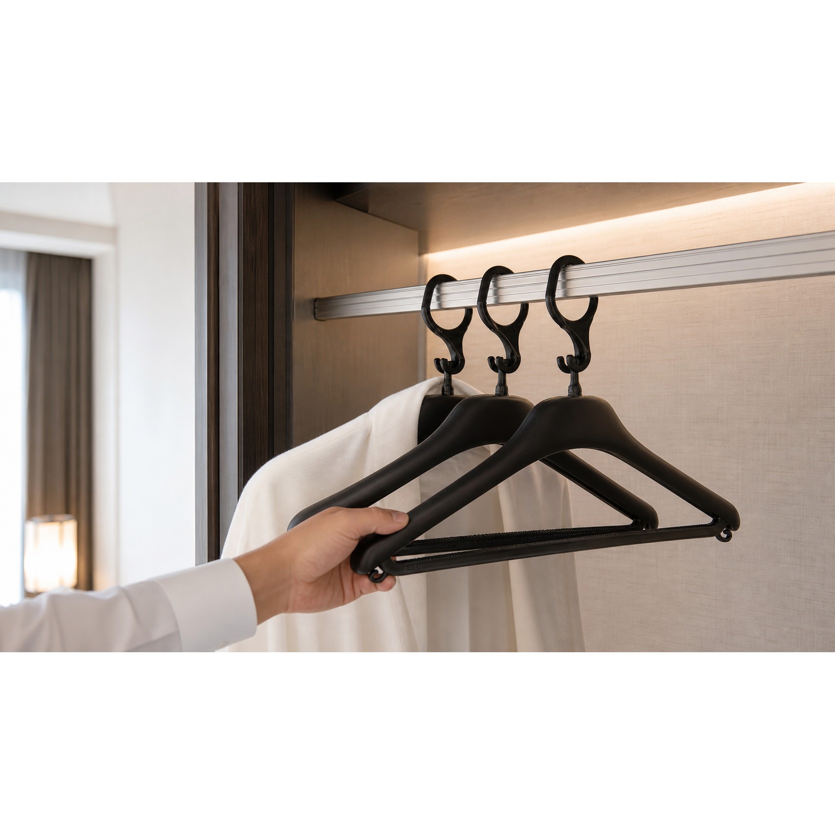 Anti Theft Hanger Plastic White Hotel attendant using black plastic anti-theft hangers with security hooks on a wardrobe rail